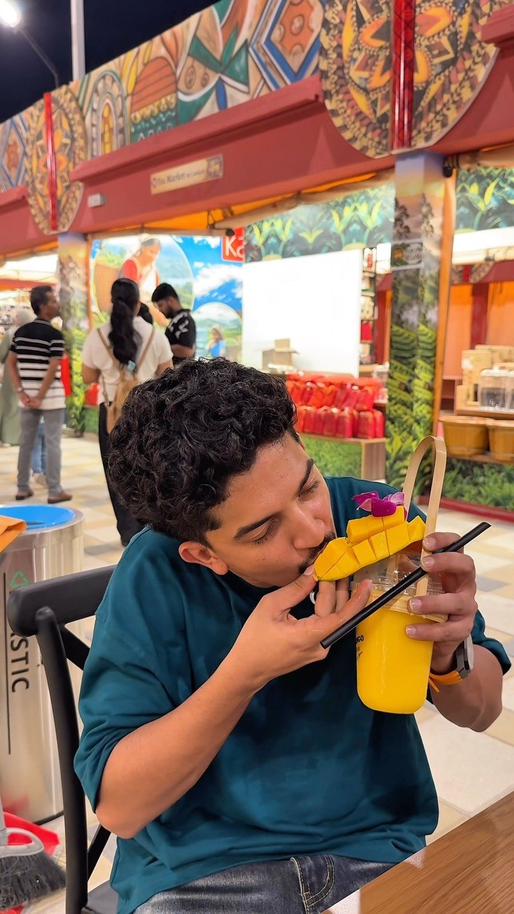 Trying a mango drink at a food court